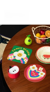 Close-up of colorful floral diatomite coasters with sun and heart patterns on wood table