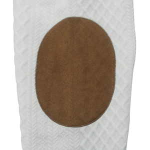 Gros plan sur le tricot jacquard blanc avec empiècement en daim marron brodé