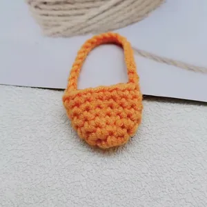 Vista dettagliata della mini borsa a tracolla arancione fatta a mano all'uncinetto con manico