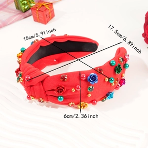 Detail view of a knotted red fabric headband with sparkling crystal and rose decorations