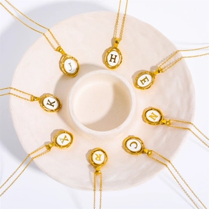 Oval gold stainless steel initial necklaces with white shell inlay and capital letters