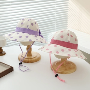 Detail of kids sun hats showing adjustable windproof drawstrings and polka dot fabric
