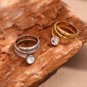 Detail of 18K gold and silver double snake head rings with white diamonds on natural stone