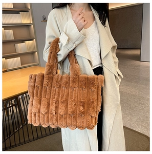 Close-up of the striped plush texture and wide handle on the brown tote bag