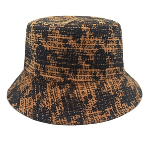 Close-up of houndstooth plaid bucket hat featuring orange and black woven texture detail