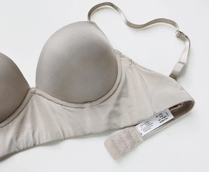 Close-up of champagne seamless bra care label detailing fabric blend and size M