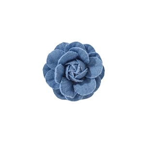 Detailed close-up of a handmade blue denim camellia flower brooch on white background