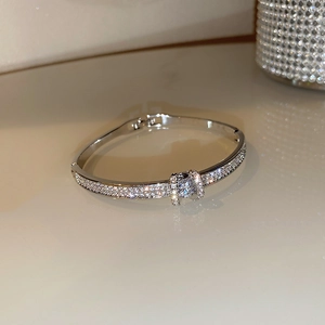 Macro shot of silver bangle featuring sparkling pavé crystals and a central diamond accent