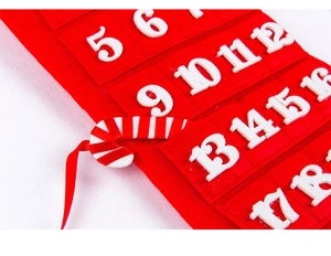 Close-up of red felt Christmas advent calendar with white numbered pockets and candy cane