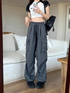 Detail view of dark grey cargo pants with drawstring waist and functional side pockets