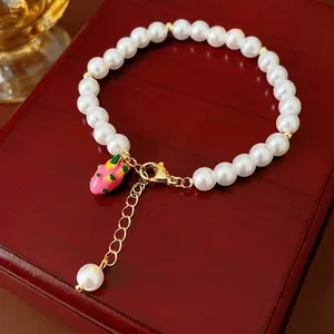 Chic gold-plated pearl bracelet with pink dragon fruit charm and adjustable clasp