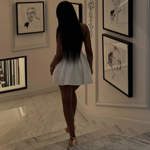Vue de dos d'une mini robe blanche dos nu à fines bretelles portée par un mannequin