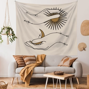 Bohemian tapestry with sun and moon line art hanging over a sofa in a warm living room