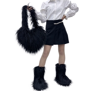 Fashionable black faux fur heart-shaped crossbody bag styled with a chic winter outfit