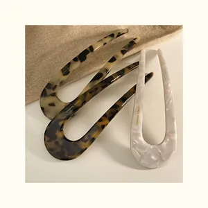 Macro detail of French style acetate U-shaped hair pins with gold France Handmade logo