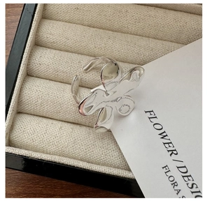Gros plan d'une bague fleur en argent 925 poli sur un présentoir beige de luxe
