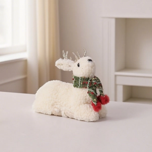 Dettaglio di renna natalizia di peluche con sciarpa rosso-verde e corna dorate