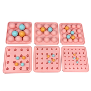 Pink silicone ice cube mold with sphere cavities and colorful balls for candy making