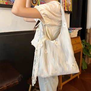 Detailed embroidery on light blue organza tote bag with lace and bow accents