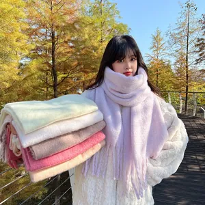 Detailed close-up of thick pastel scarves with fringes in Morandi colors for winter