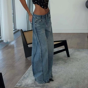 Detail of blue high-waisted wide-leg jeans with vintage stitching and pleated side seams