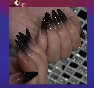 Close-up of long stiletto press-on nails with black to nude ombre gradient finish