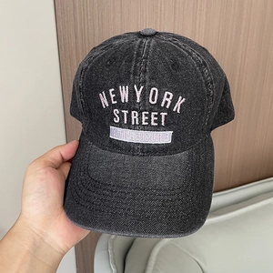 Close-up of New York Street embroidery on washed denim baseball cap with vintage finish