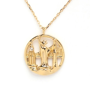 Macro shot of gold S925 silver necklace with city landmark relief in a round pendant