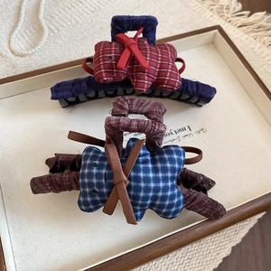 Macro view of plaid fabric bear hair claws and bows on a jewelry display tray