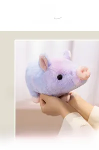 Gros plan d'un doudou cochon en peluche dégradé coloré tenu entre les mains douces
