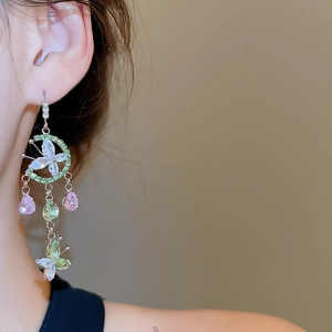 Close-up of elegant flower glass bead tassel earrings featuring butterfly and moon details