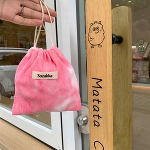 Pink tie-dye corduroy drawstring pouch with white ropes and textured fabric detail