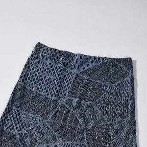 Dettaglio del tessuto in pizzo a maglia blu e nero su una gonna a sirena slim