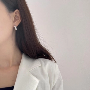 Minimalist 925 sterling silver spiral hoop earrings worn by a model in a side profile view