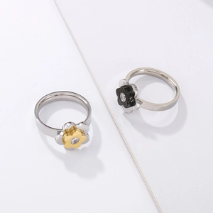 Close-up of floral titanium steel rings with crystal center and two-tone polished finish