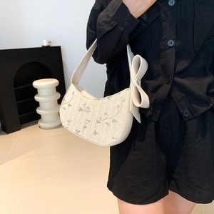 Straw bucket bag for women with floral embroidery and large bow accent in cream white