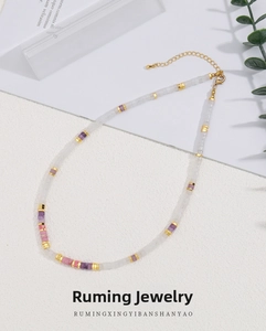 Macro view of a colorful natural stone beaded necklace with 18k gold-plated spacers
