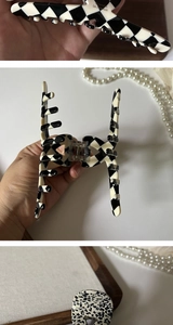 Detailed views of a checkerboard acetate hair claw clip with Barrette La France gold logo