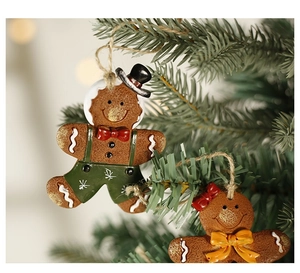 Detailed view of gingerbread man ornaments hanging on green Christmas tree branches
