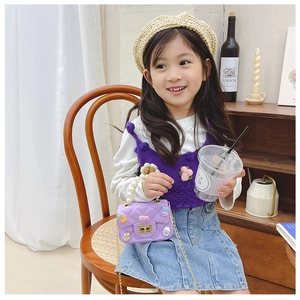 Detail of purple quilted girls crossbody bag with pearl handle and floral charms