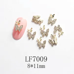 Detalle macro de adornos de uñas mariposa 3D oro 8x11mm con cristales y alas huecas