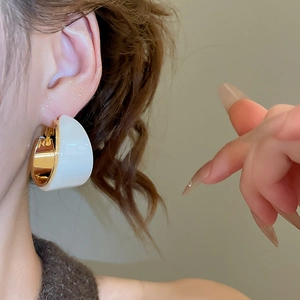Gros plan de boucles d'oreilles en C plaquées or 18 carats avec résine blanche