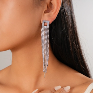 Primo piano di una modella che indossa orecchini pendenti a nappa argento con strass