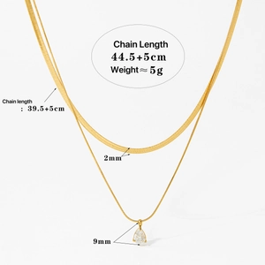 Detail of gold double-layered necklace with dimensions, snake chain, and zircon pendant