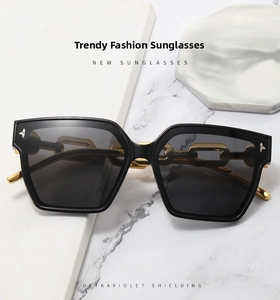 Macro detail of chic gold chain temples on oversized black frame square sunglasses