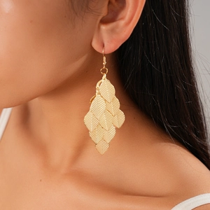 Detail of gold metal layered leaf earrings with crinkled texture on female model