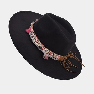 Detail of black wool fedora featuring colorful ethnic embroidery and shell tassel trim