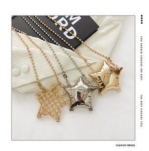 Detail view of gold and silver star pendants with woven and polished metallic textures