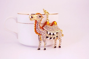 Close-up of golden desert camel keychain with sparkling rhinestones and lobster clasp