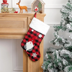 Detail of red and black plaid Christmas stocking with gnome embroidery on fireplace mantel